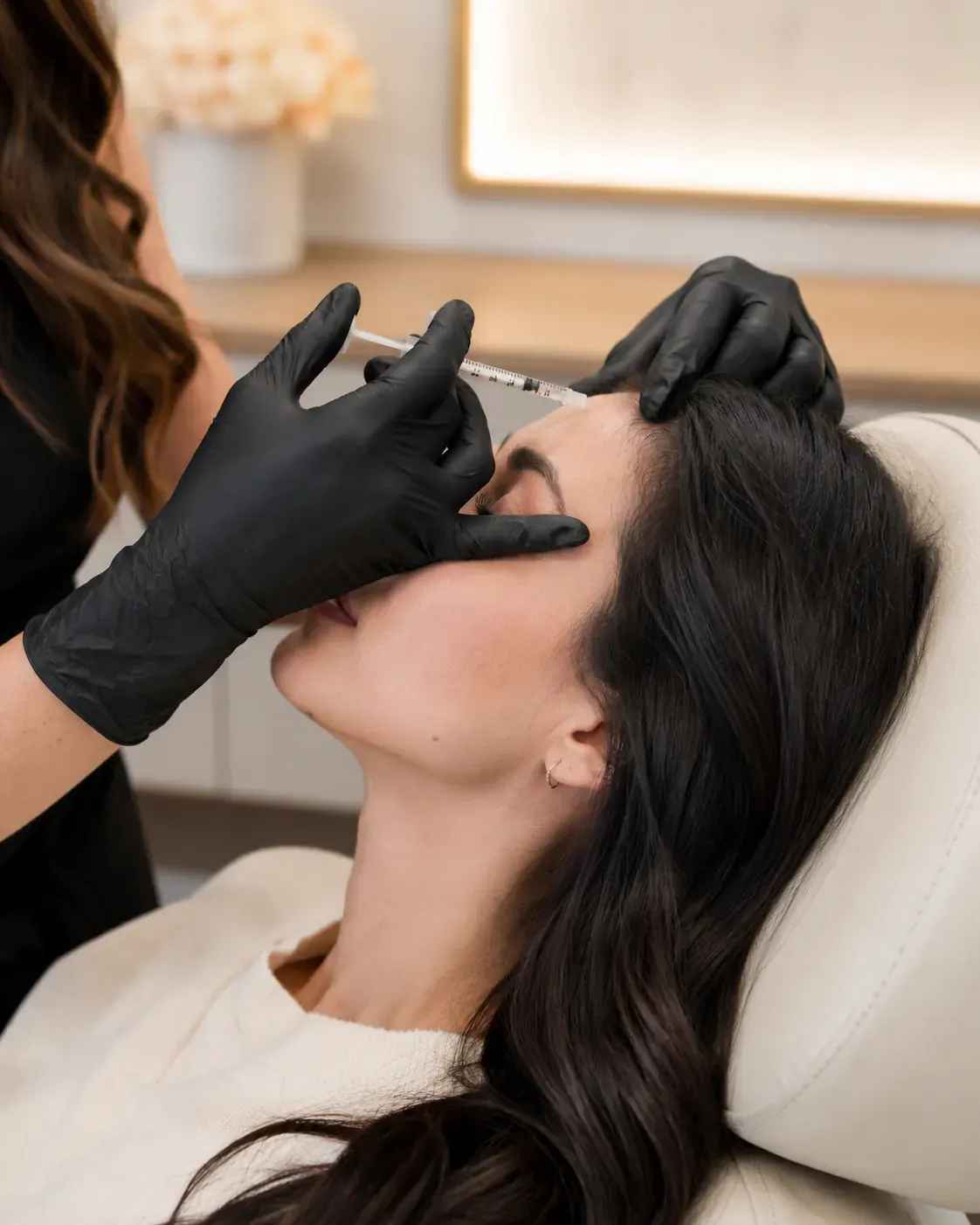 Professionnelle réalisant une injection esthétique au niveau du front